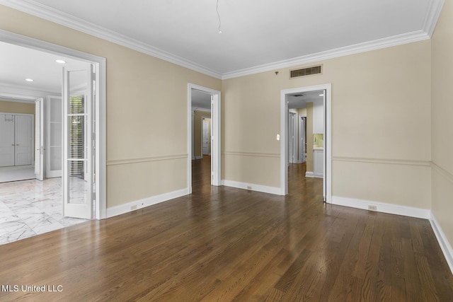 spare room with baseboards, ornamental molding, and visible vents