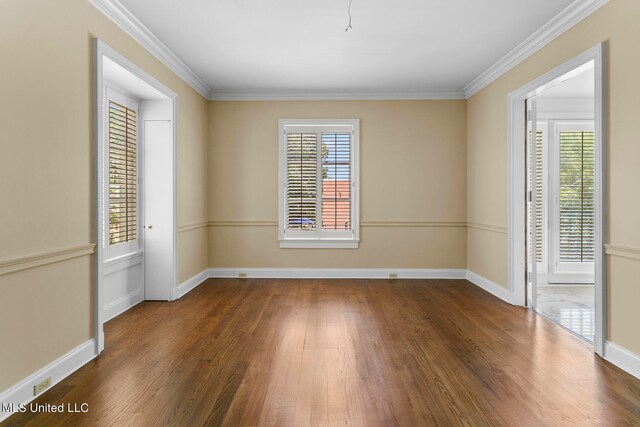 empty room with crown molding, a healthy amount of sunlight, and dark wood-type flooring