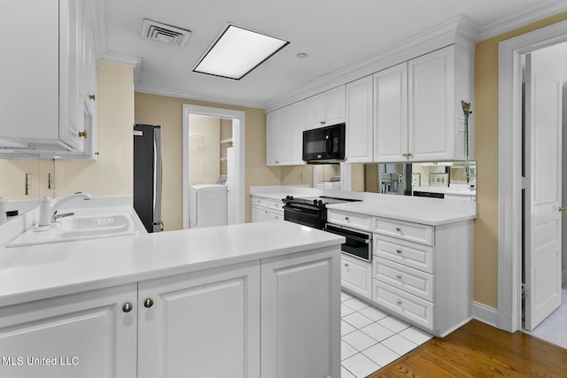 kitchen featuring kitchen peninsula, white cabinets, black appliances, and light wood-type flooring