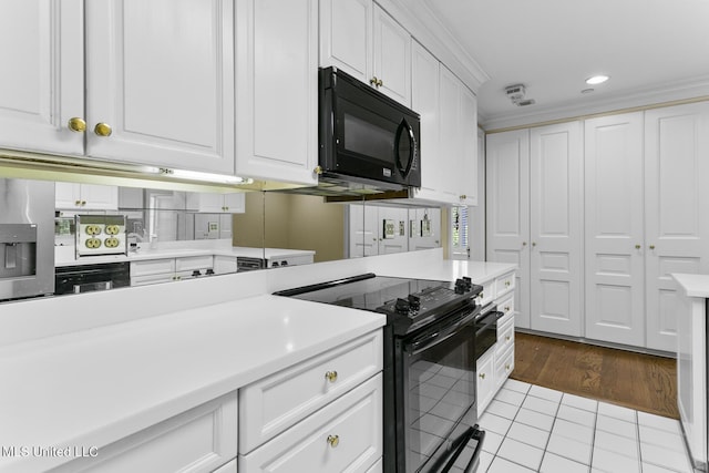 kitchen featuring white cabinetry, black appliances, light countertops, and recessed lighting