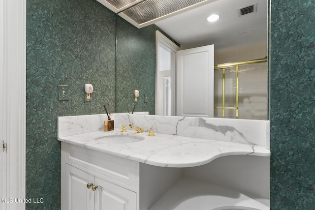 bathroom featuring visible vents, vanity, and wallpapered walls