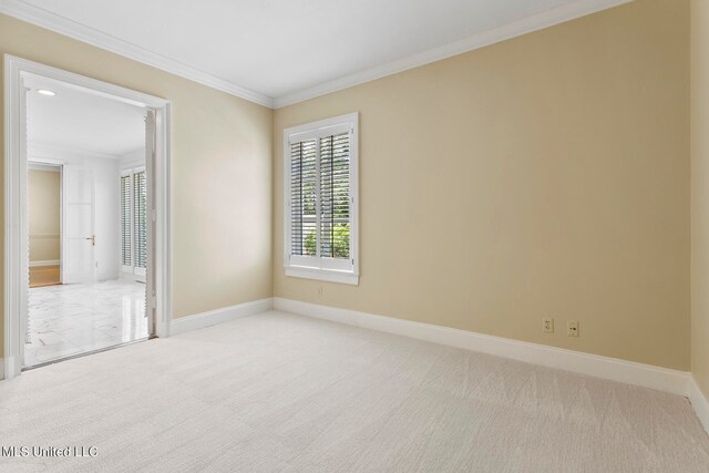 carpeted spare room featuring crown molding