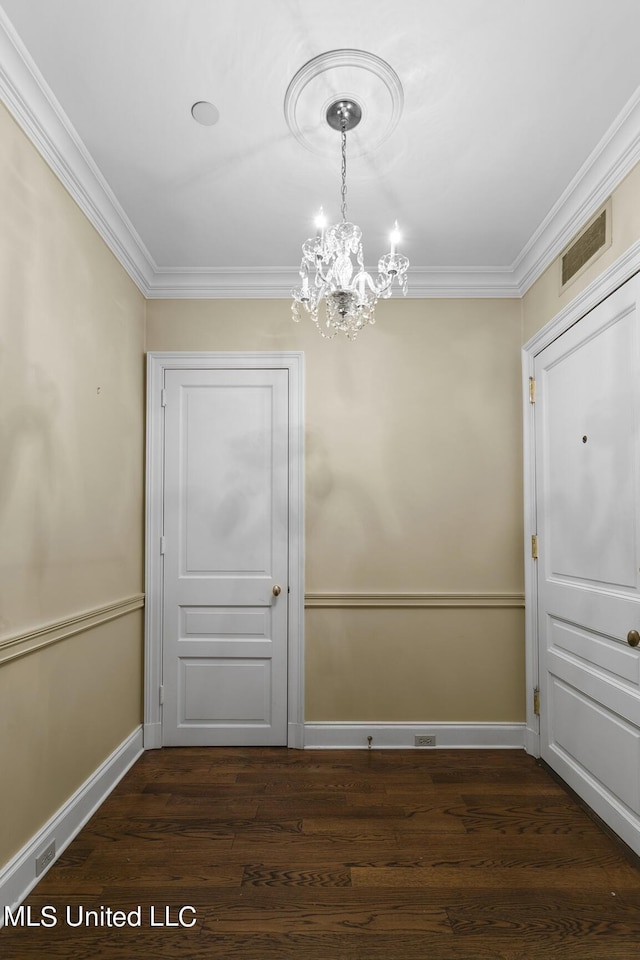 unfurnished dining area with ornamental molding, baseboards, visible vents, dark wood-style flooring, and a notable chandelier