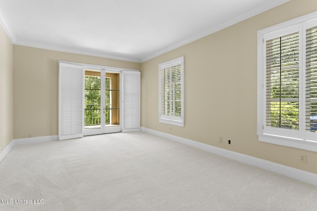 empty room featuring baseboards, carpet flooring, and crown molding