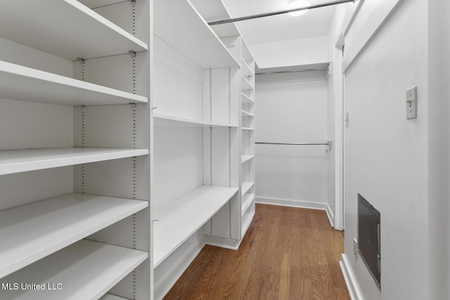 walk in closet with visible vents and wood finished floors