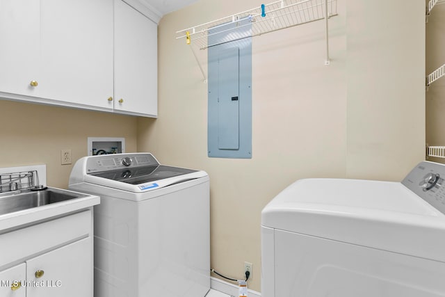 laundry area with sink, washer and dryer, cabinets, and electric panel