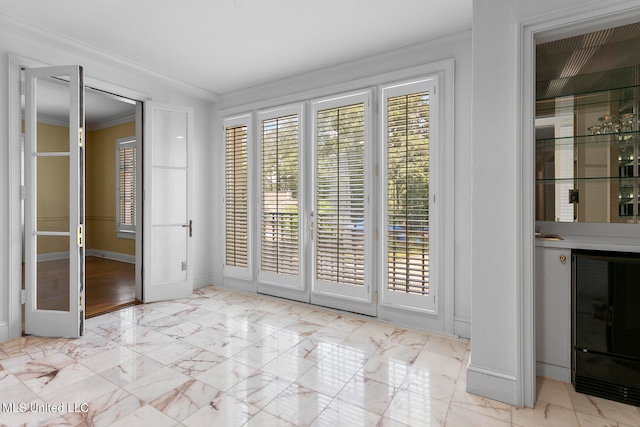 interior space with crown molding and beverage cooler