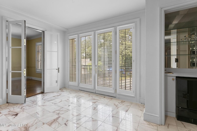 interior space featuring baseboards, marble finish floor, and ornamental molding