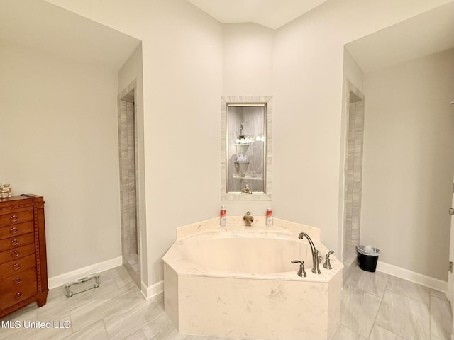 3020 Makenlee St, Southaven, MS 38672 - bathroom with a bath, baseboards, and marble look tile flooring
