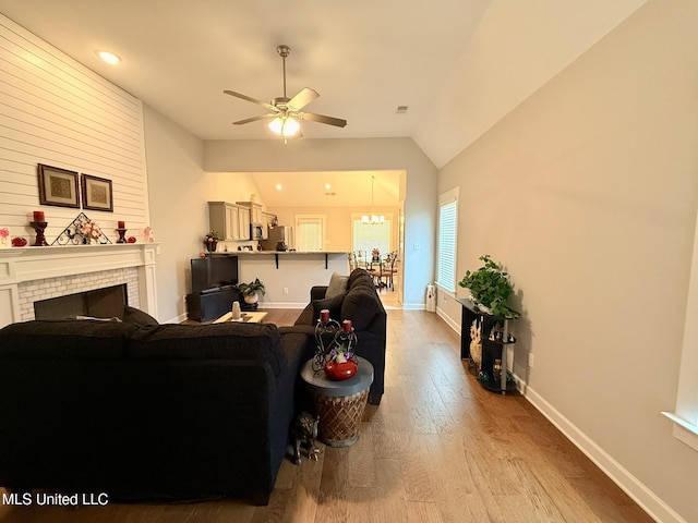 3020 Makenlee St, Southaven, MS 38672 - living area with a ceiling fan, wood finished floors, vaulted ceiling, a brick fireplace, and baseboards