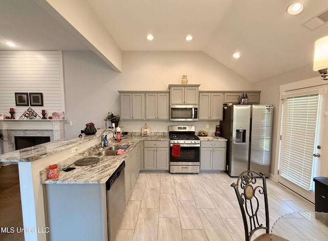 3020 Makenlee St, Southaven, MS 38672 - kitchen featuring appliances with stainless steel finishes, a sink, gray cabinetry, a peninsula, and light stone countertops