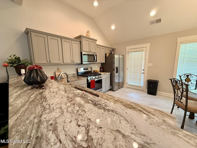 3020 Makenlee St, Southaven, MS 38672 - kitchen with appliances with stainless steel finishes, gray cabinets, light stone counters, recessed lighting, and high vaulted ceiling