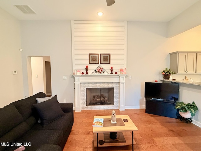 3020 Makenlee St, Southaven, MS 38672 - living area featuring light wood-style floors, a tiled fireplace, recessed lighting, and baseboards