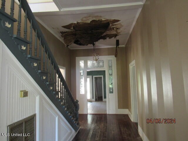 foyer featuring ornamental molding, hardwood / wood-style flooring, and a chandelier