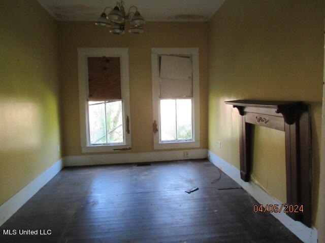 unfurnished living room with dark hardwood / wood-style flooring and a chandelier