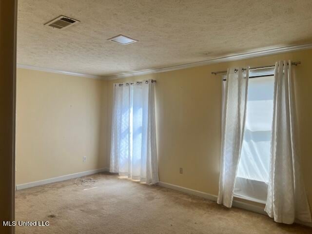 unfurnished room with light carpet, ornamental molding, and a textured ceiling