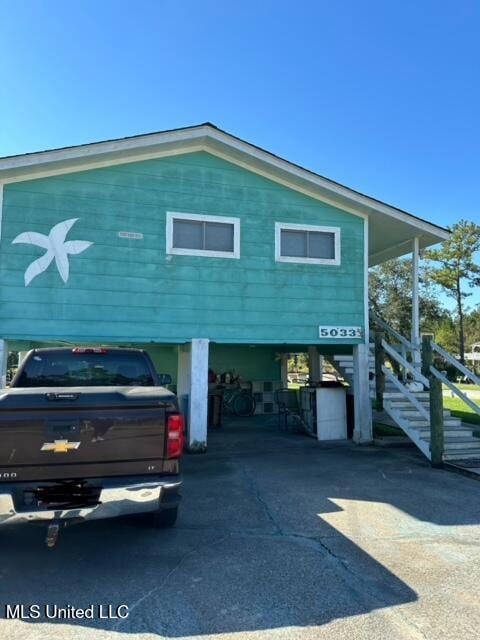 view of front of property with a carport and stairway