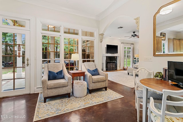 living room with ceiling fan, ornamental molding, and plenty of natural light