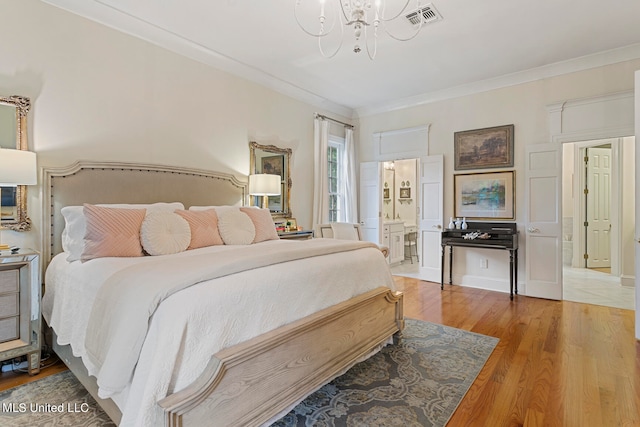 bedroom with ensuite bathroom, crown molding, wood-type flooring, and a chandelier