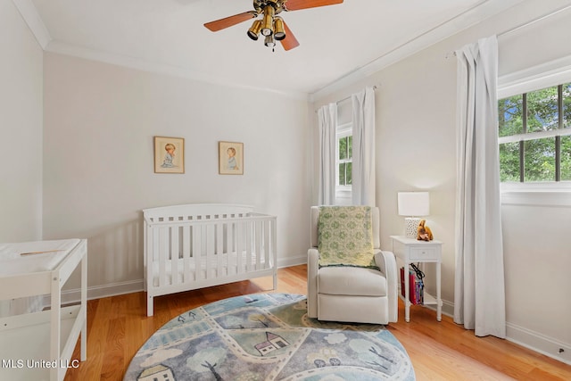 bedroom with ceiling fan, hardwood / wood-style flooring, and multiple windows