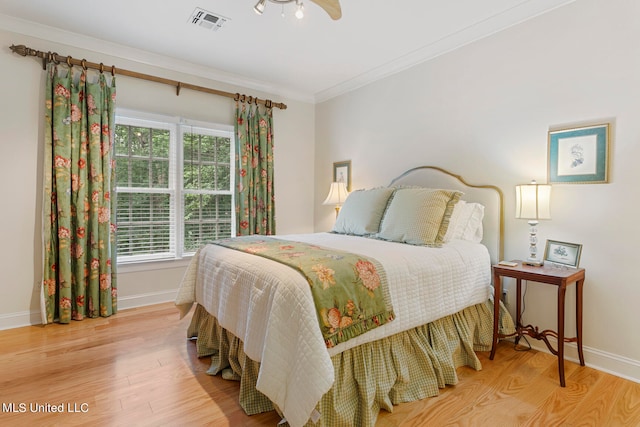 bedroom with ceiling fan, wood-type flooring, and ornamental molding