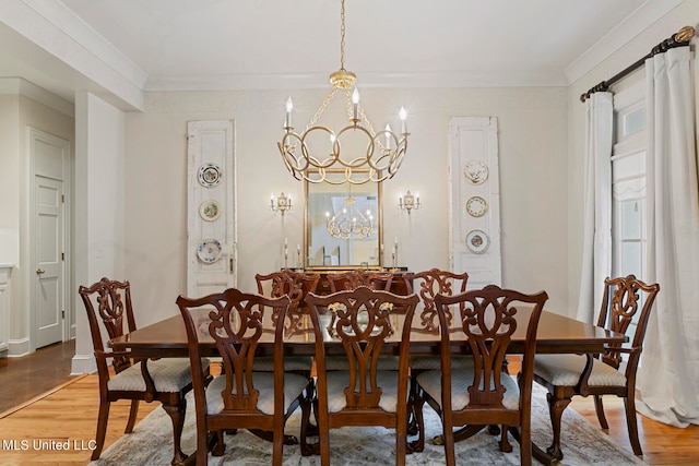 dining space with crown molding, hardwood / wood-style flooring, and a chandelier