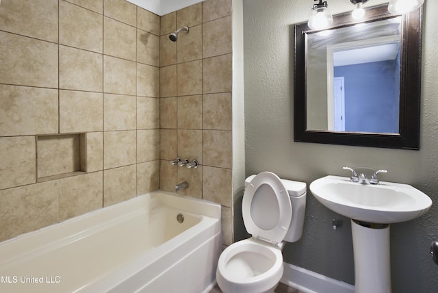 bathroom with a textured wall, shower / bathing tub combination, and toilet