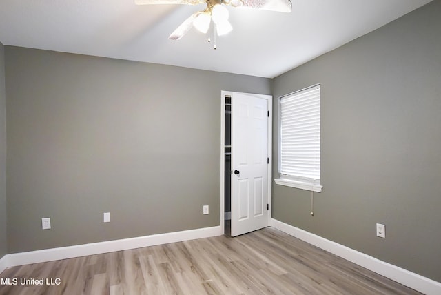 spare room with light wood-style flooring, baseboards, and ceiling fan