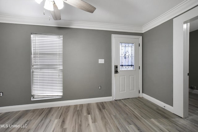 foyer with baseboards, ceiling fan, wood finished floors, and crown molding