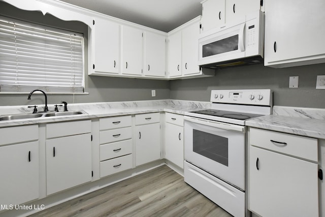 kitchen featuring light countertops, white appliances, a sink, and white cabinets