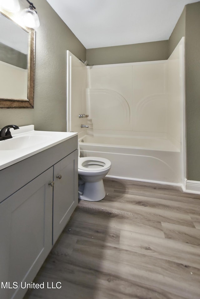 bathroom with vanity, shower / bathing tub combination, wood finished floors, and toilet