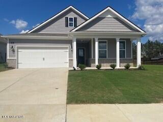 view of front of property featuring a garage, a porch, and a front yard