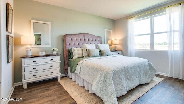 bedroom with dark wood-type flooring and multiple windows