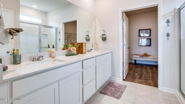 bathroom with tile patterned flooring, walk in shower, and vanity