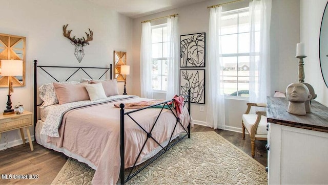 bedroom with multiple windows and hardwood / wood-style floors