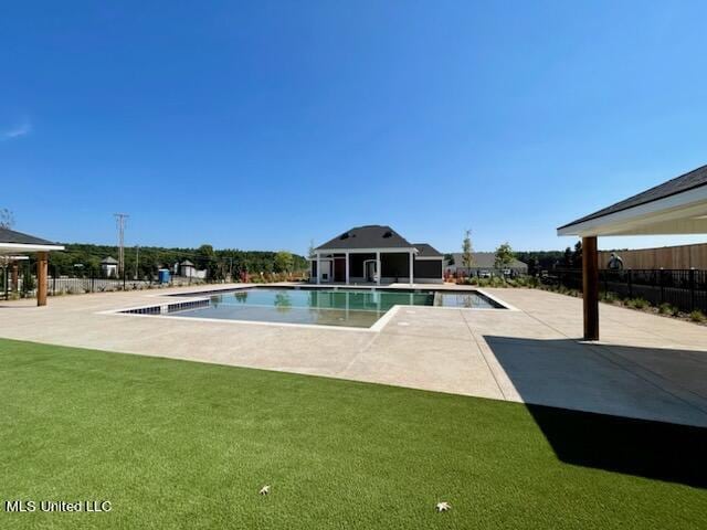 view of swimming pool featuring a patio area and a yard