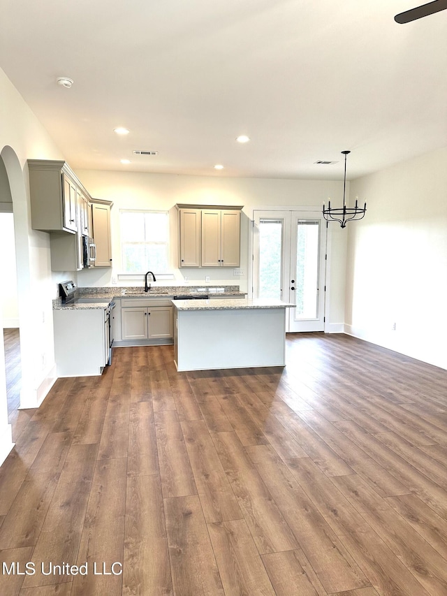 kitchen featuring a kitchen island, dark wood-type flooring, hanging light fixtures, and a healthy amount of sunlight