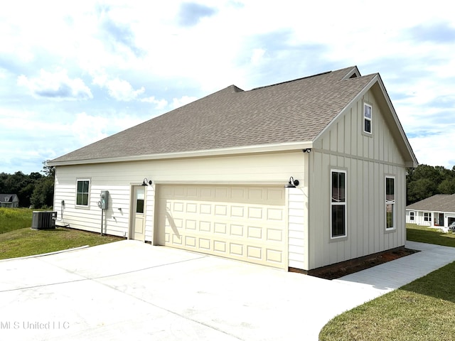 exterior space featuring a yard, cooling unit, and a garage