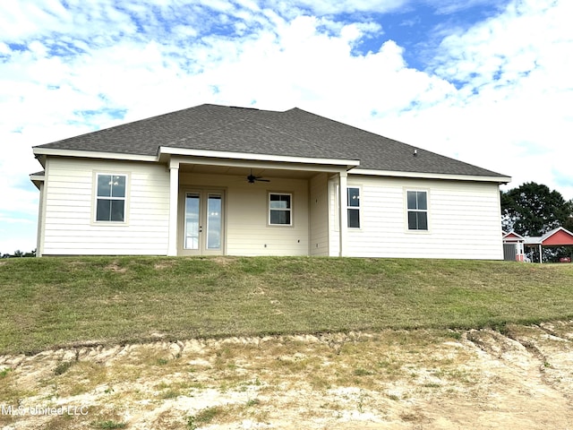 back of house featuring a lawn and ceiling fan