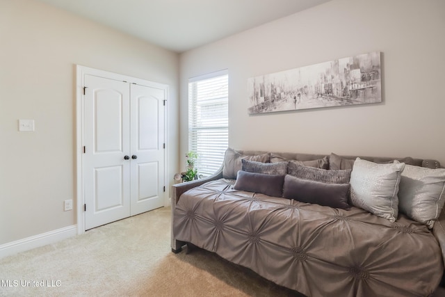 carpeted bedroom with baseboards and a closet