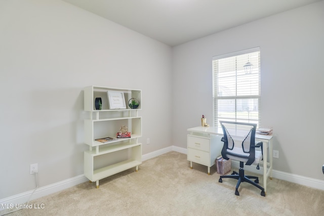 home office with baseboards and light carpet