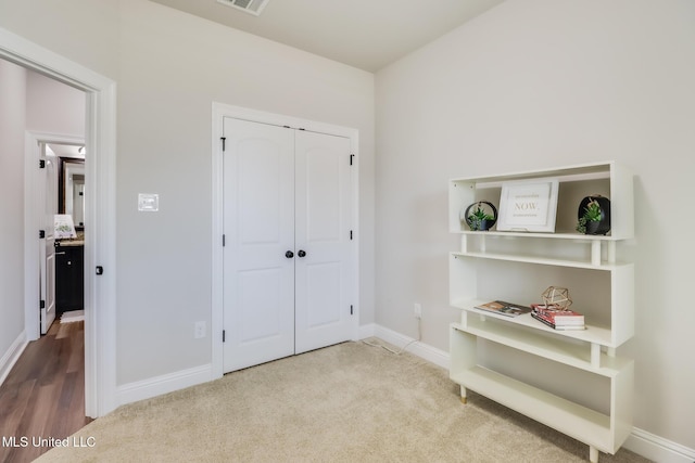 carpeted bedroom with baseboards, visible vents, and a closet