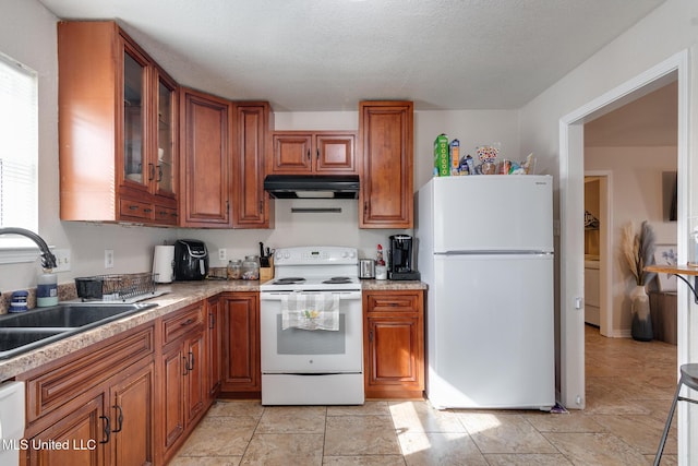 kitchen with sink, white appliances, and a textured ceiling