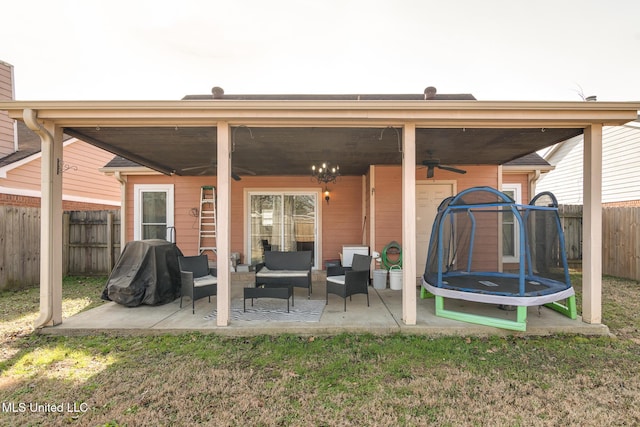 rear view of property with a patio, outdoor lounge area, a trampoline, a yard, and ceiling fan