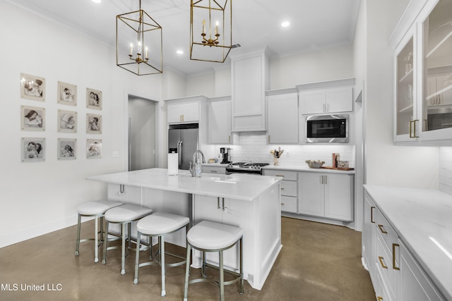 212 Ashbury Cv, Canton, MS 39046 - kitchen with decorative backsplash, a kitchen island with sink, a breakfast bar, a sink, and stainless steel appliances