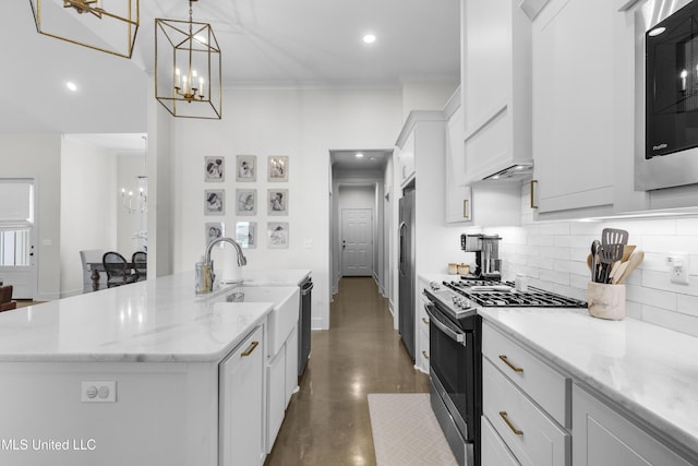212 Ashbury Cv, Canton, MS 39046 - kitchen with a kitchen island with sink, fridge, stainless steel gas stove, and a notable chandelier