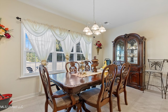 tiled dining area featuring a notable chandelier and plenty of natural light