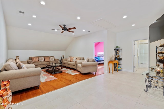 living room featuring ceiling fan, vaulted ceiling, and light hardwood / wood-style flooring