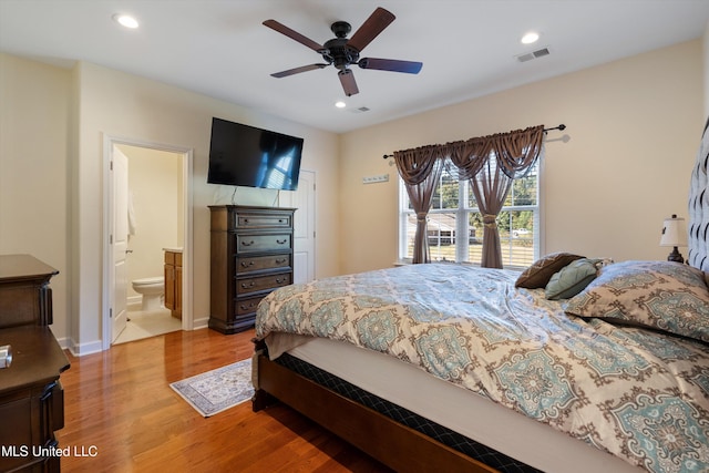 bedroom featuring ensuite bath, hardwood / wood-style floors, and ceiling fan