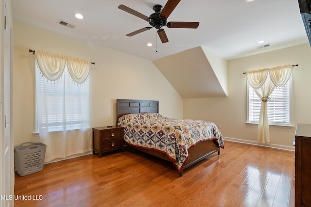 bedroom with ceiling fan, vaulted ceiling, and light wood-type flooring